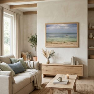 Minimalist living room mockup featuring a large framed seascape photography print of a calm turquoise ocean beach over a wooden console table with earthy, organic modern home decor.