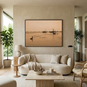Organic modern living room mockup featuring a large black-framed warm sepia seascape photography print of traditional dhow boats in Zanzibar, styled above a curved cream sofa with minimalist Wabi-Sabi home decor.